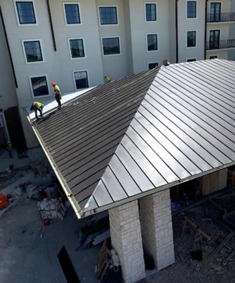 Crew installing standing seam metal roof panels on a commercial project in Chester